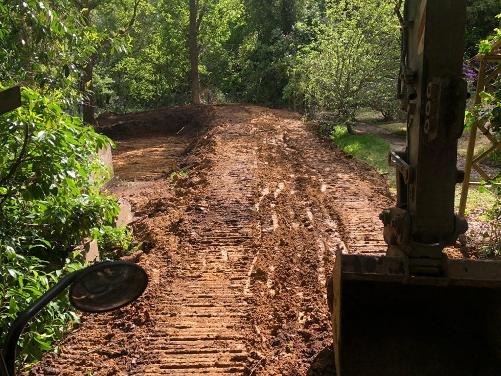 A concrete foundation being poured in a backyard.